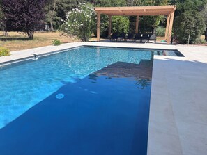 A clear swimming pool with a wooden pergola and lounge chairs in the background. - House / Villa - Callian (Callian)