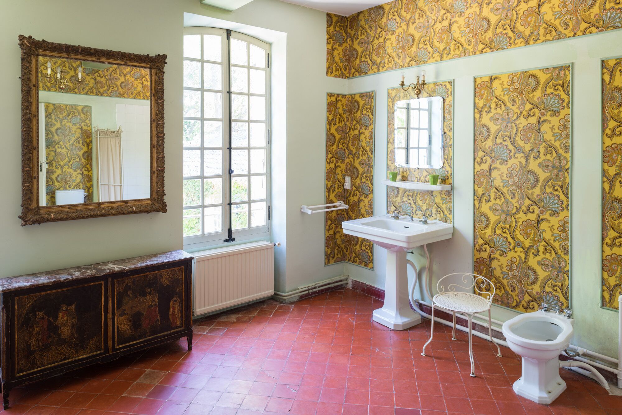 A bathroom with a large mirror, a sink, a toilet, and a radiator.