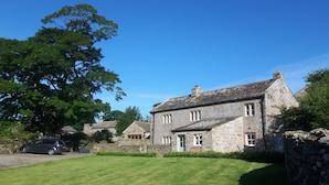 A stone house with a well-maintained lawn and a parked car. - Beautiful Grade II listed house with stunning uninterrupted views. Sleeps 8 (Carlton-in-Coverdale, Leyburn, Yorkshire)