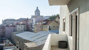 A balcony with a view of a cityscape, including a prominent building with a dome.