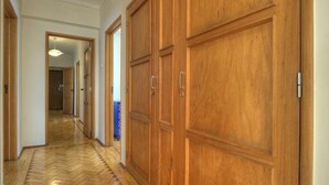 A hallway with wooden doors and a herringbone floor.