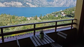 Een balkon met uitzicht op een meer en bergen.