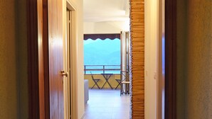 Een hotelgang die uitkomt op een balkon met uitzicht op zee.