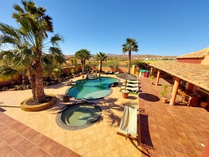 A pool area with two pools, palm trees, lounge chairs, and a covered seating area. - Dream villa with private tennis court & heated pool & children’s play area  (Antigua Las Palmas Fuerteventura)