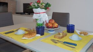 A dining table with a meal setup including bread, apples, and a croissant. - "Between Norba and Norma" cozy apartment (Norma)