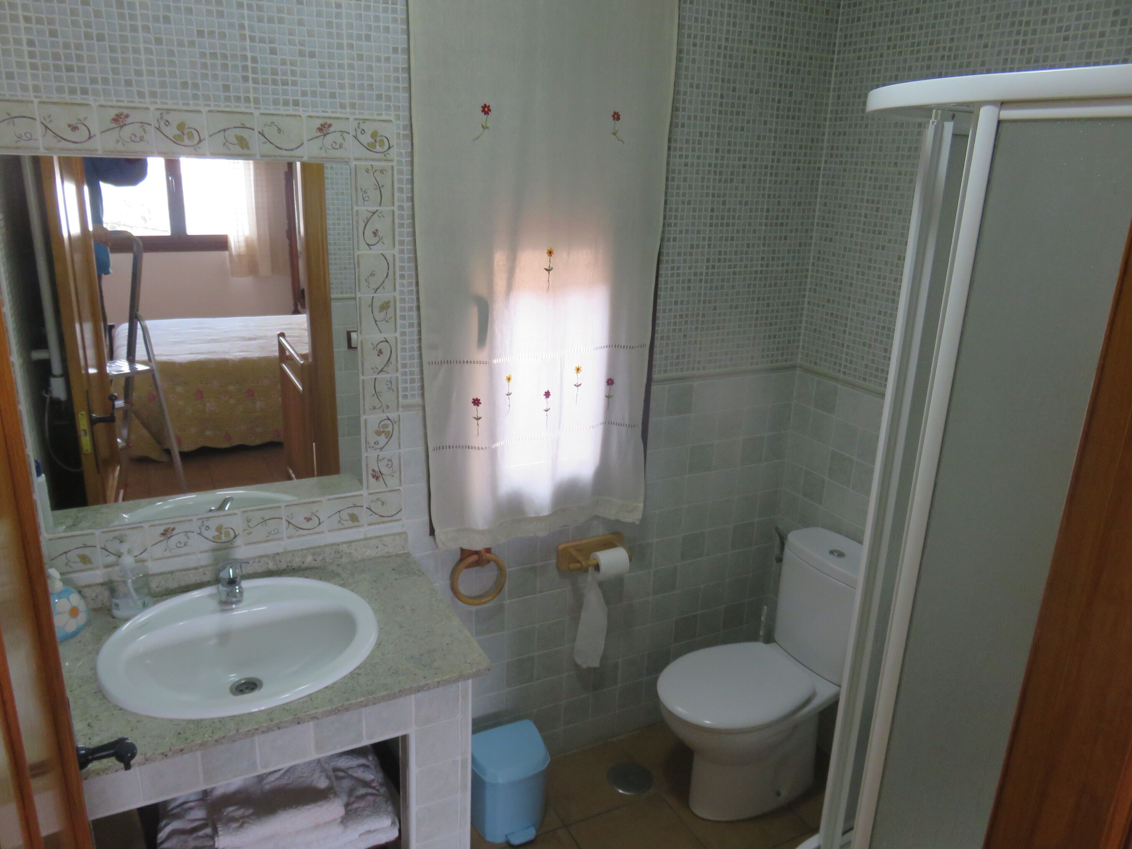 Een badkamer met een wastafel, toilet en douche.
