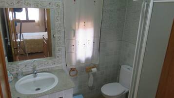 Een badkamer met een wastafel, toilet en douche.