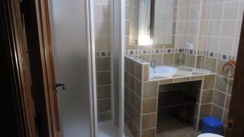 Een badkamer met een douche, wastafel en toilet.