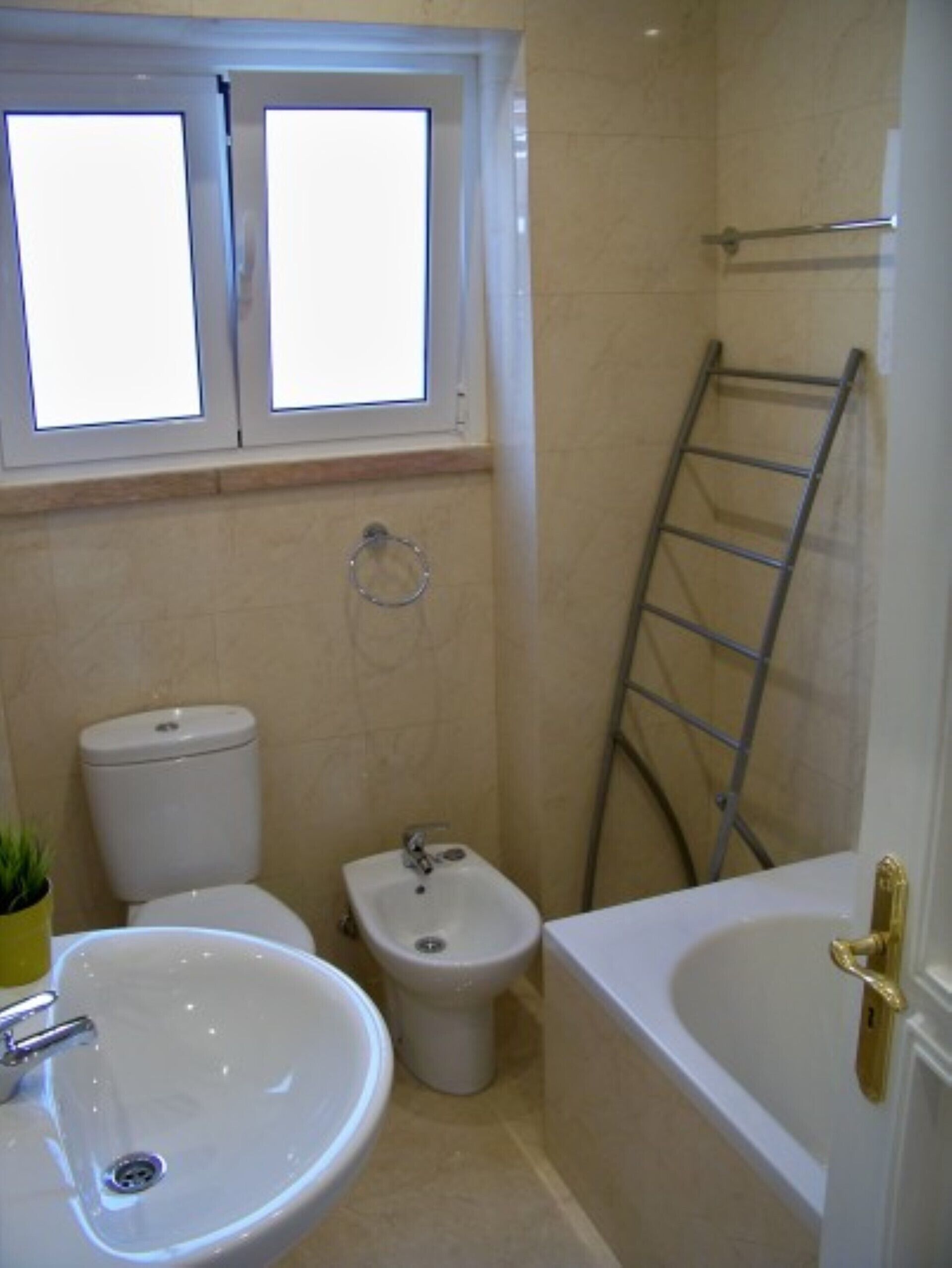 Une salle de bain comprenant des toilettes, un bidet, un lavabo et une baignoire.