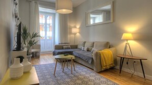A modern living room with a sofa, a coffee table, a lamp, and a patterned rug.