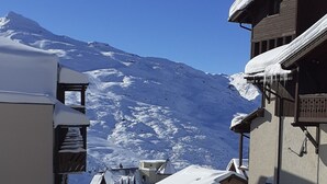 Un pueblo cubierto de nieve con edificios y una montaña al fondo.
