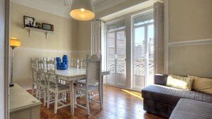 Una habitación con una mesa de comedor y sillas, un sofá y un ventanal con vistas.