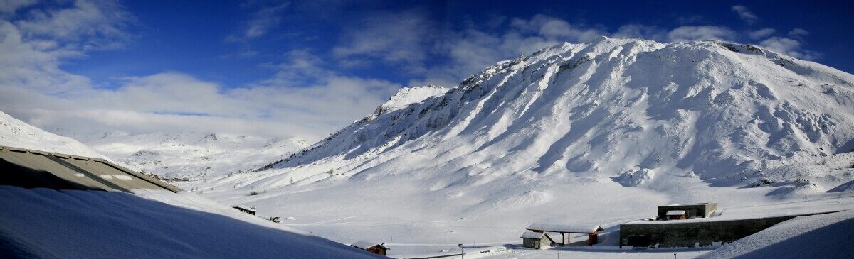 Ein mit Schnee bedeckter Berg unter blauem Himmel.