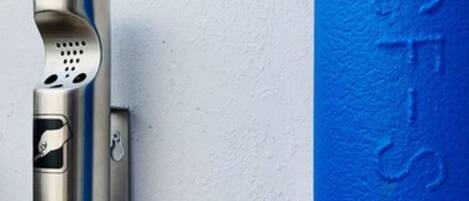 A metallic object with a keyhole and a blue stripe, mounted on a textured wall.