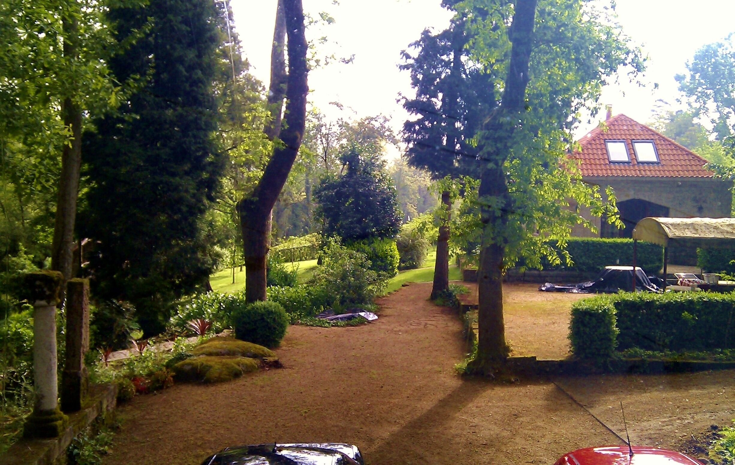 Un camí al jardí que condueix a una casa amb teulada vermella.