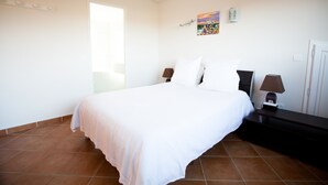 A bedroom with a large bed, a nightstand, a lamp, a wall-mounted air conditioner, and a window. - 
Private villa  and large  pool 08 mn from Porto Vecchio and marvellous beaches
 (Porto-Vecchio)