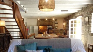 A cozy living room with a sofa, a coffee table, and a hanging light fixture. - Plobannalec Lesconil: Country holiday home - Plobannalec-Lesconil (Plobannalec-Lesconil)