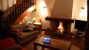 A cozy living room with a fireplace, a sofa, a chair, and a coffee table. - House / Villa - Loctudy (Loctudy)