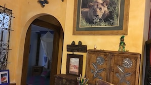 Een kamer met een houten kast, een ingelijst beeld van een leeuw, en een decoratieve vlinder.