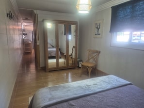 A bedroom with a bed, a chair, a wardrobe, and a window. - Sandra's house  (Arona)