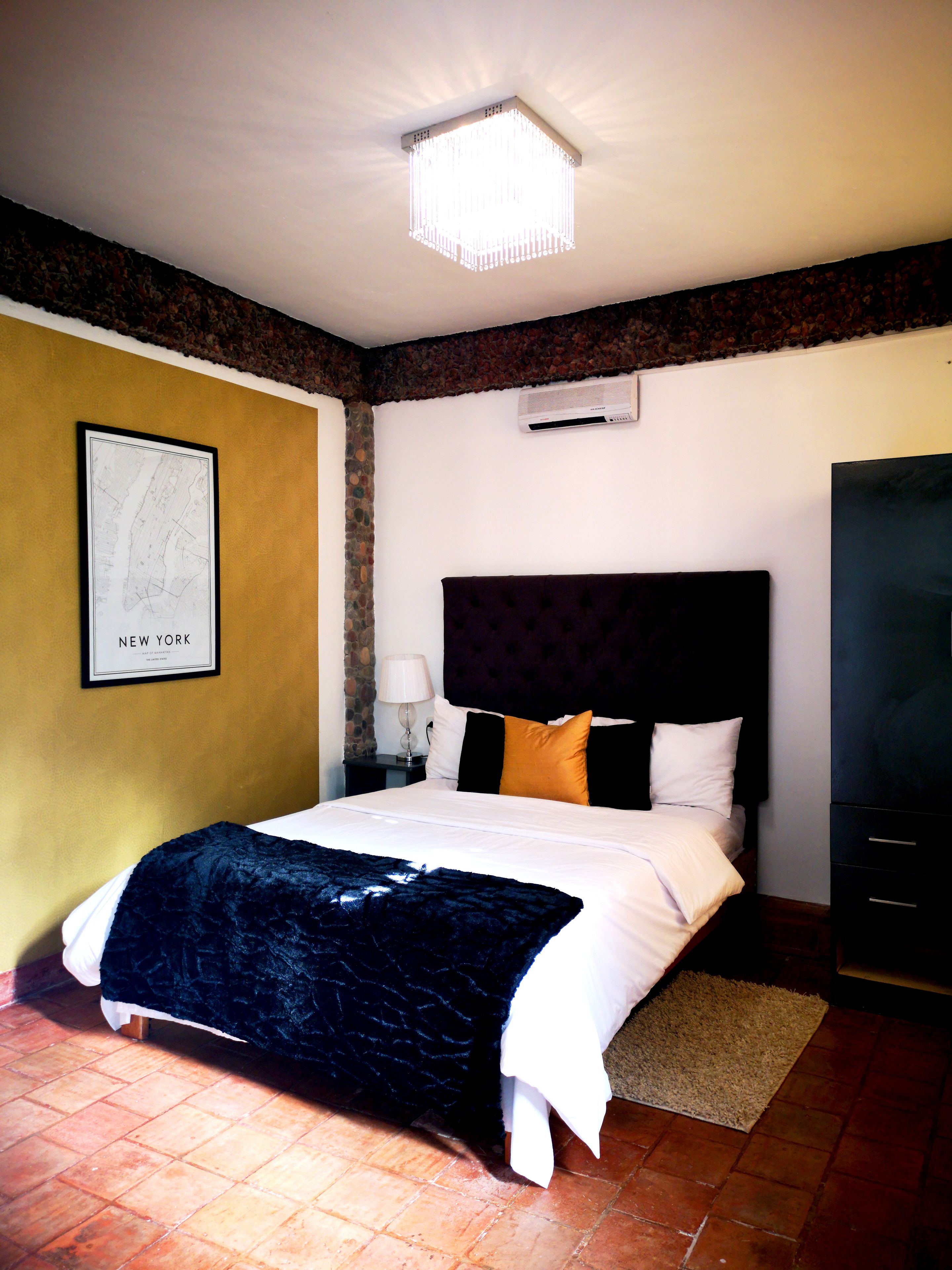 A hotel room with a large bed, a map on the wall, and an air conditioning unit.
