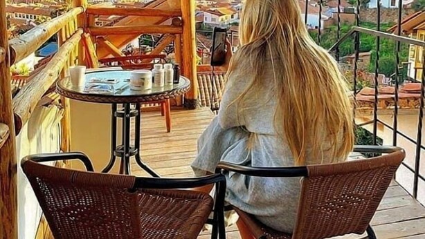 A wooden deck with a table and chairs, overlooking a mountainous landscape. - Cities of the World - Apartments Cusco (Cusco)