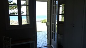 A room with a bed, a chair, and a view of the beach through a window. -  Our small seafront paradise !!! (Akrata)