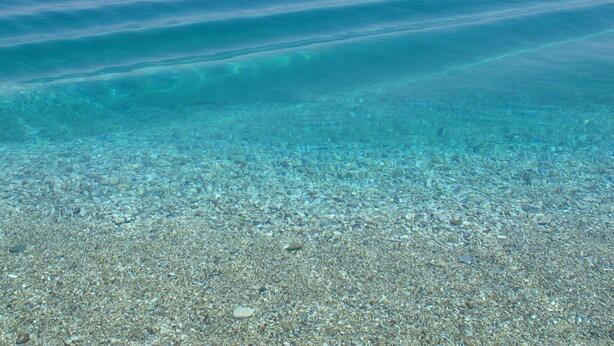 A clear view of a beach with a pebbly shore and calm water extending to the horizon. -  Our small seafront paradise !!! (Akrata)