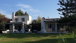 A modern two-story house with a well-maintained lawn and outdoor seating area. -  Our small seafront paradise !!! (Akrata)