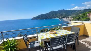 Una terrazza con tavolo e sedie affacciata su una vista costiera.