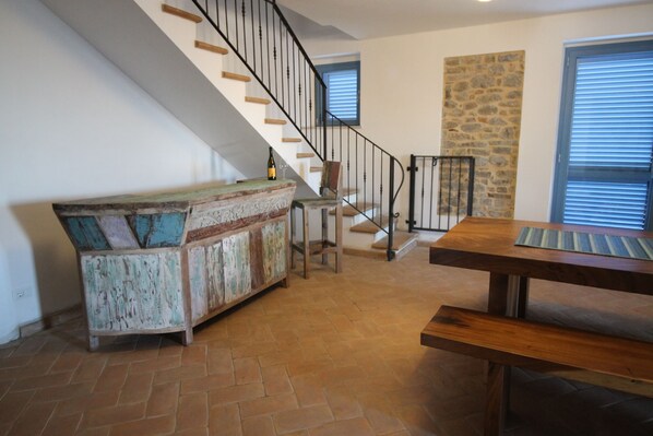 A spacious living area with a wooden bench, a rustic wooden bench with cushions, a staircase with a metal railing, and a stone accent wall. - Newly renovated farmhouse with pool - views of the sea and mountains (Crocetta Santa Maria)