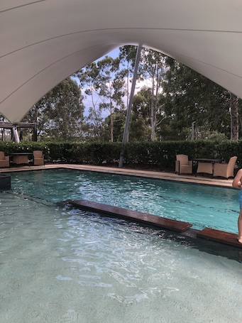 Una piscina al aire libre, sillones reclinables de piscina