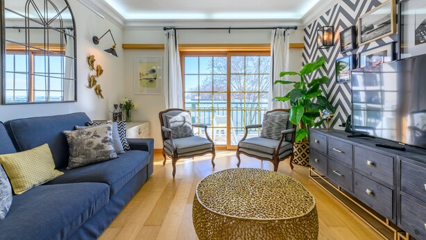 A modern living room with a blue sofa, two armchairs, a round coffee table, and a TV on a dark wooden cabinet. - CARCAVELOS BEACH. A wonderful 2 bedroom apartment (Carcavelos)
