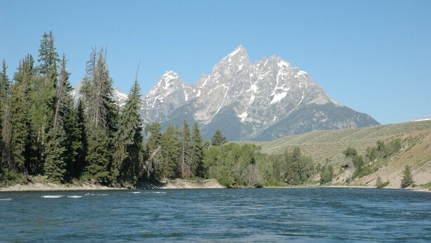 Un lac avec une chaîne de montagnes en arrière-plan.