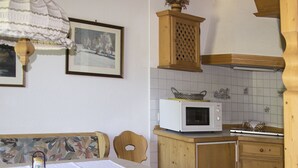Eine Küche mit Holzausstattung, einer Mikrowelle und einem Tisch mit Untersetzer.