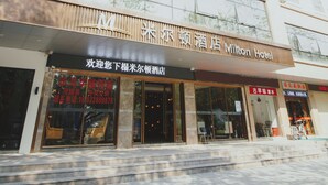 A hotel with a modern facade, large windows, and a sign indicating it is the Milton Hotel.