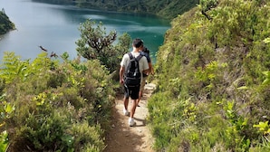 A hiking trail leading to a lake with lush greenery and hills in the background. - Casa da Adega - Holiday Home 2 Minutes from the Beach (Ribeira Chã)