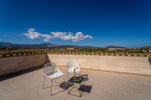 An outdoor terrace with two white chairs and a small table, overlooking a mountainous landscape. - Finca Eden Son Manyo 222 with pool in Mallorca (Sa Pobla)