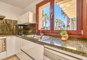 A kitchen with granite countertops, stainless steel appliances, and wooden cabinets. - Finca Eden Son Manyo 222 with pool in Mallorca (Sa Pobla)
