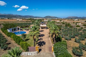 A residential property with a swimming pool, palm trees, and a view of distant mountains.