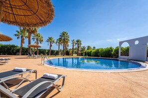 A pool area with lounge chairs, palm trees, and a clear blue sky. - Finca Eden Son Manyo 222 with pool in Mallorca (Sa Pobla)