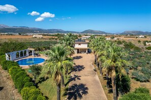 Et sted med swimmingpool, en overdækket terrasse og udsigt til fjerne bjerge.