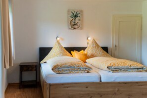 Ein Bett mit Holz-Kopfteil, zwei Nachttische und eine Wandleuchte.