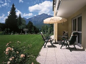 A patio with outdoor furniture and a view of mountains.
