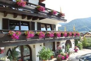 A building with multiple balconies adorned with hanging flower baskets.
