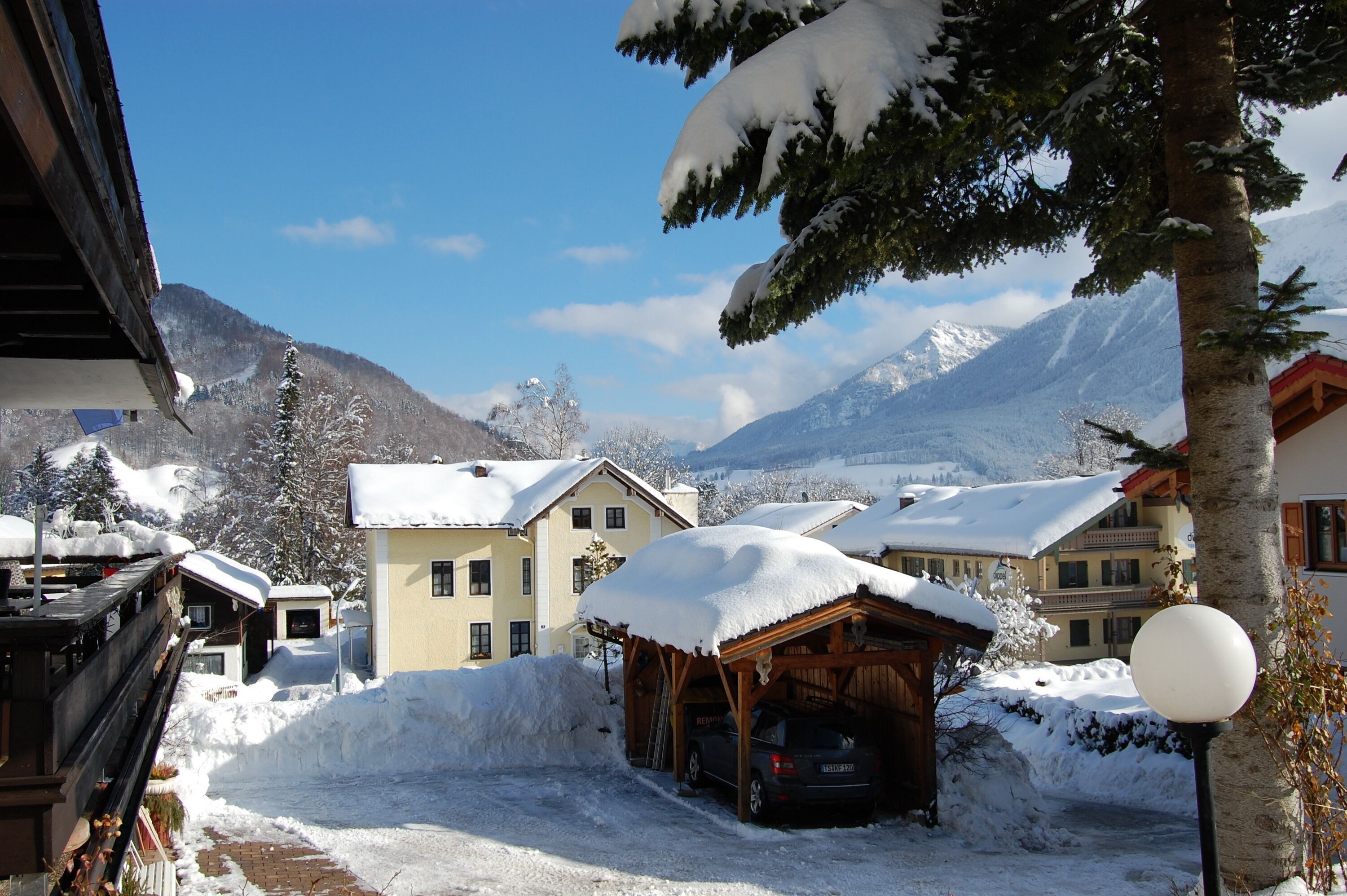 Un village de montagne enneigé, avec des bâtiments en bois et un ciel dégagé.