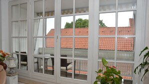 A room with large windows, a white radiator, and a potted plant. - Exclusive maisonette 83sqm, quiet, central location, in the old town (Lüneburg)