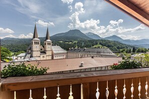 Une église à deux flèches, entourée de montagnes et de verdure.