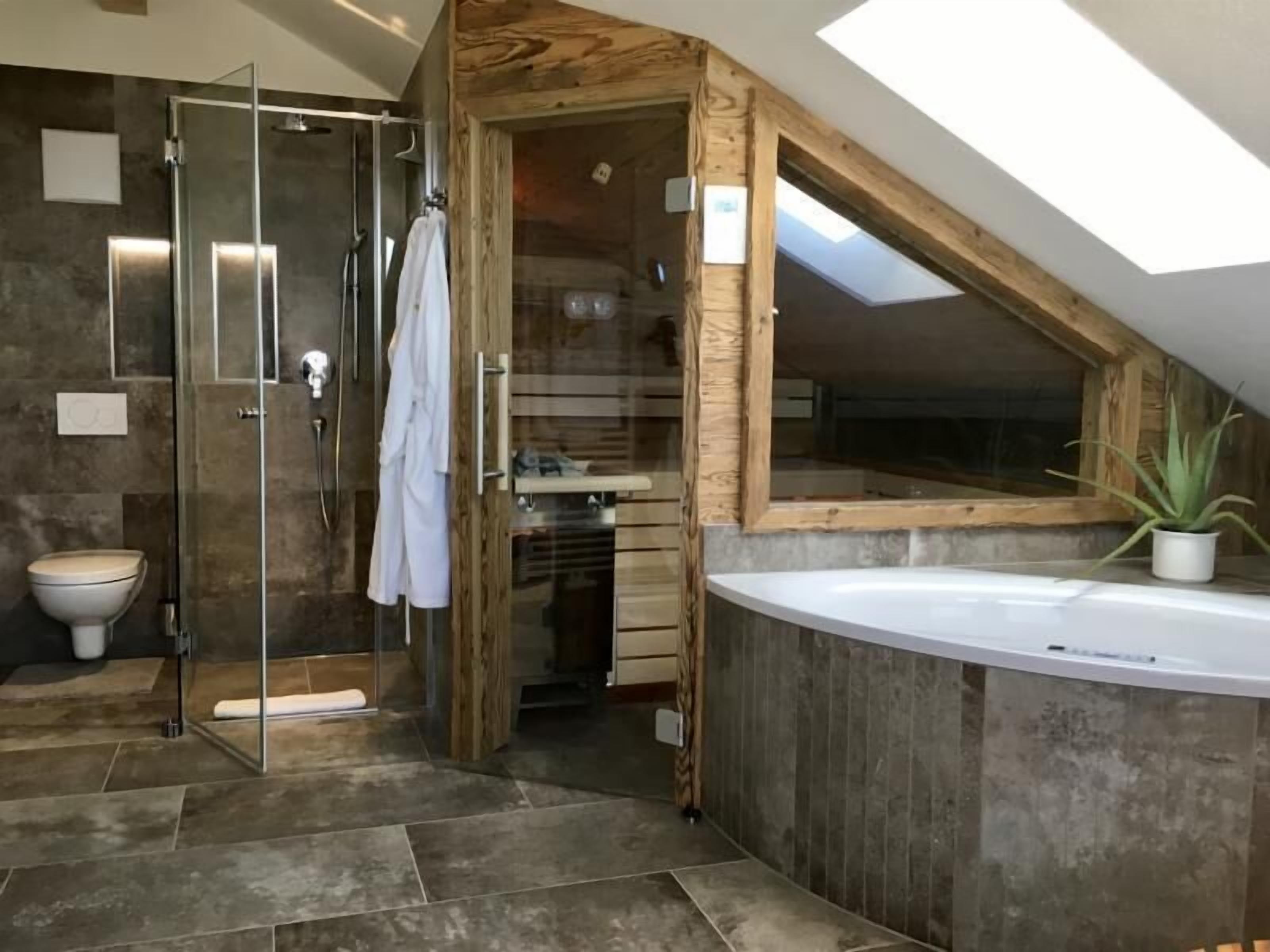 Bathtub, hair dryer, bathrobes, towels