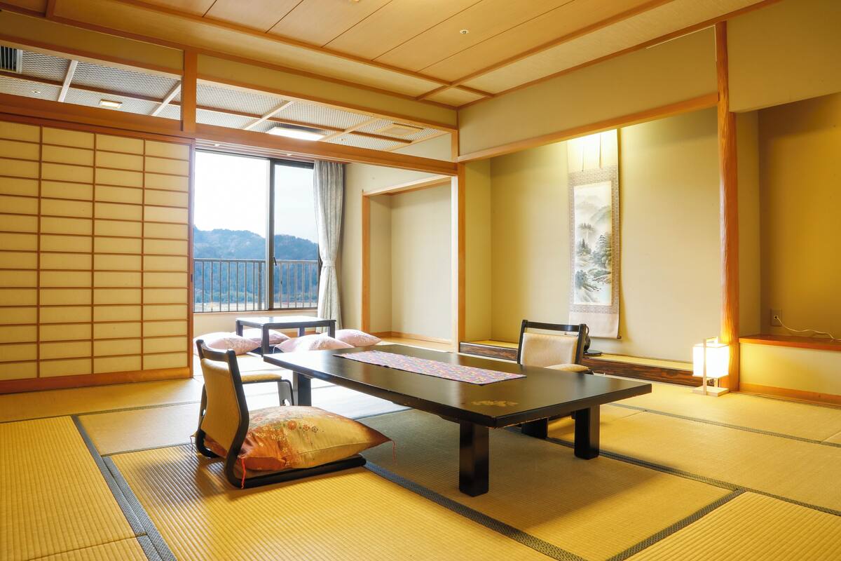 A traditional Japanese room with tatami flooring, a low table, and cushions.